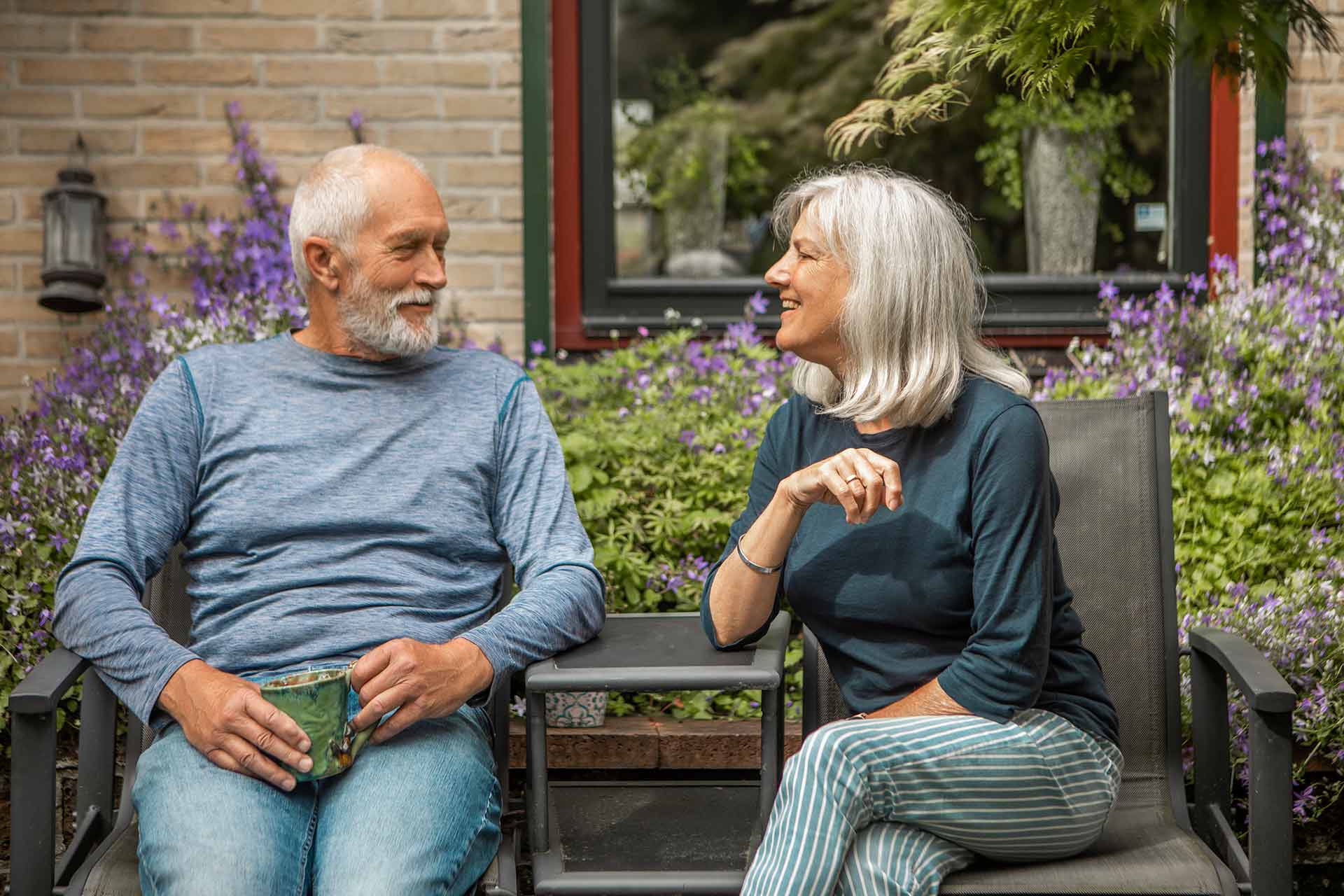 An older couple talking outside.